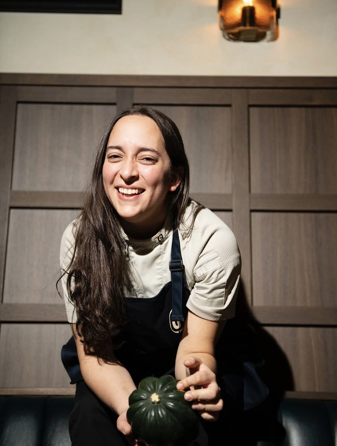 Chef Paula Endara smiling, holding a squash