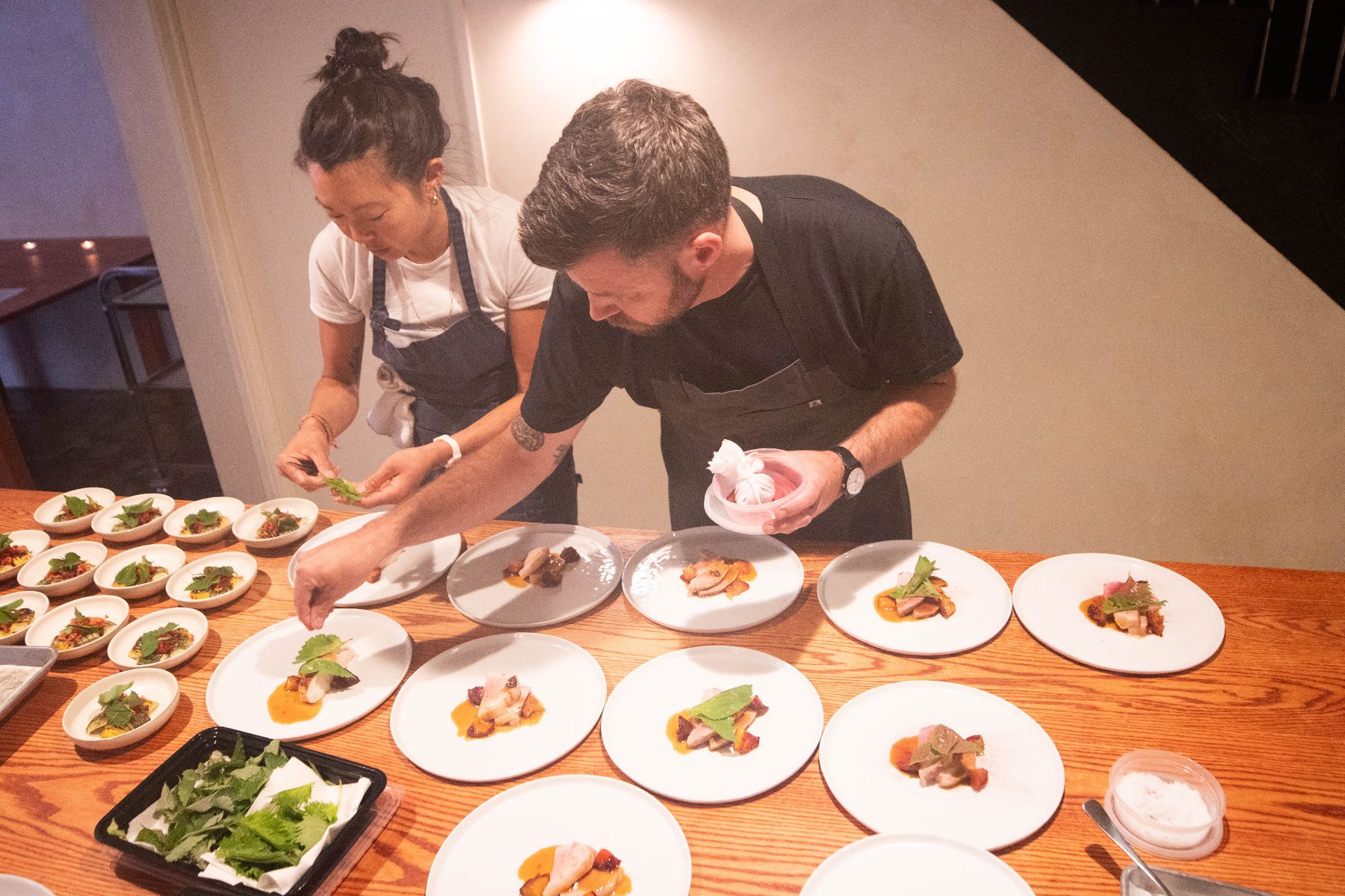 Chefs garnishing plates from above