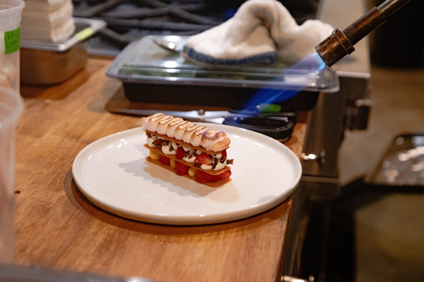 A plated dessert being torched during service