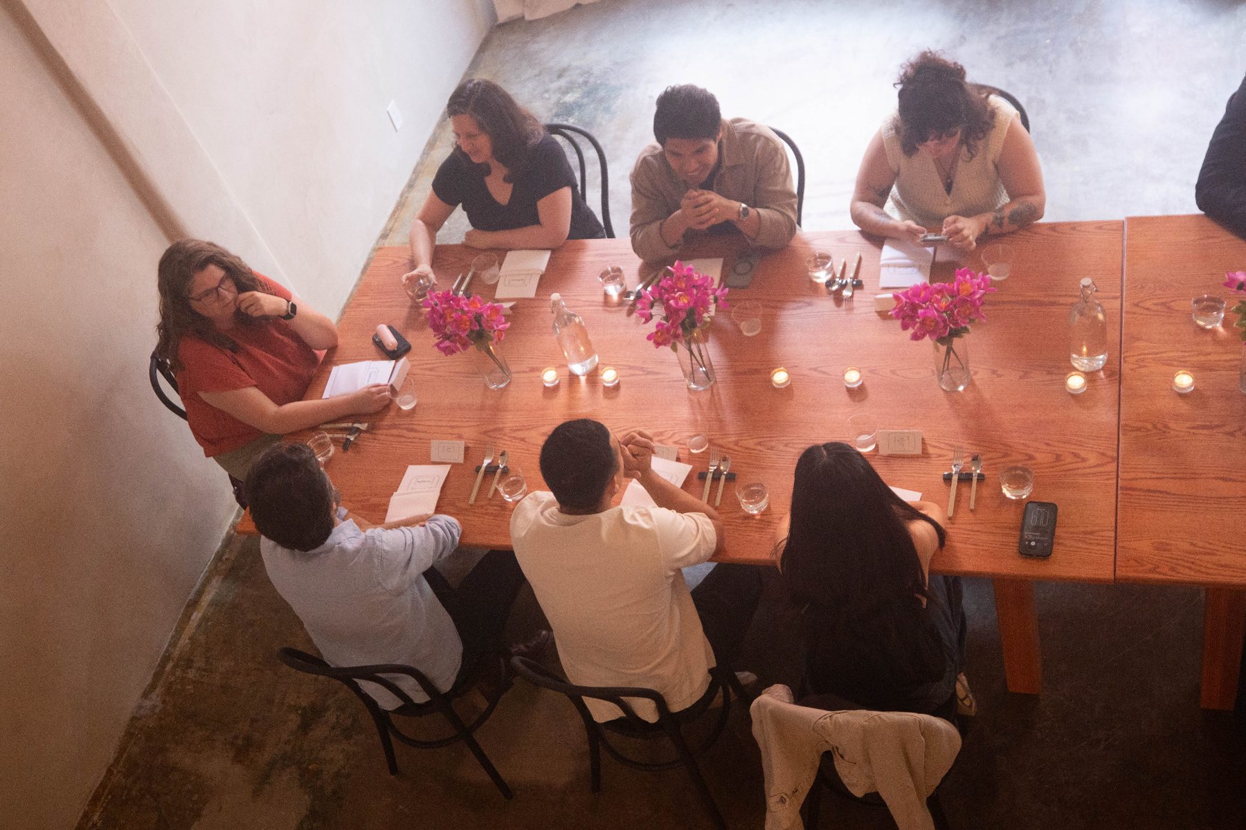 Guests seated around a long dinner table from above